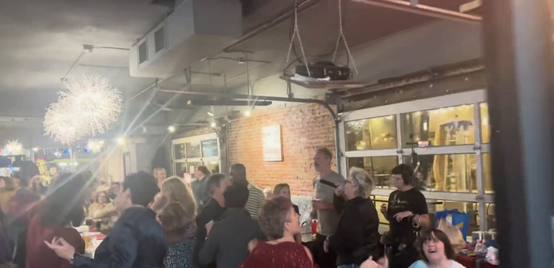 A busy evening at Brewability with people dancing and standing together under coloured lights.