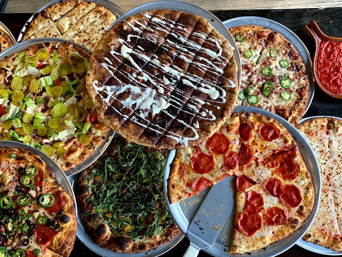 A table filled with Brewability pizzas ready to share.
